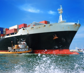tugboat pushing a monster freighter in miami seaport